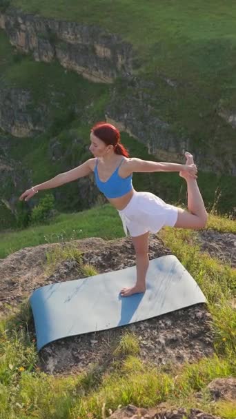 垂直录像 运动女性在日落时在山顶上做瑜伽动作 运动女子训练和伸展运动在山区进行 健康的生活方式 泽纳主义 锻炼的概念 慢动作 — 图库视频影像