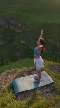 Dikey Video, Genç Atletik Kadın Dağın Tepesinde Meditasyon, Zen Yoga Doğada Meditasyon. Güzel Slim Girl dışarıda ruhani yoga yapıyor. Yavaş Hareket.