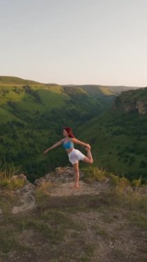 Dikey Video, Atletik Kadın Gün Batımında Üst Dağ 'da Yoga Poz Veriyor. Spor Kız Eğitimi ve Dağlarda Esneme Egzersizleri Yapıyor. Sağlıklı Yaşam Tarzı, Zenizm, Spor Konsepti. Yavaş Hareket