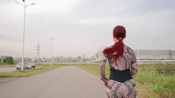 运动服跑步时 身材苗条 一头红头发的女运动员 女运动员在白天参加户外运动 女赛跑选手跑步训练 慢动作 — 图库视频影像