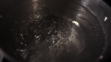 Water is boiling in a pot on the stove. Boiling water in slow motion.
