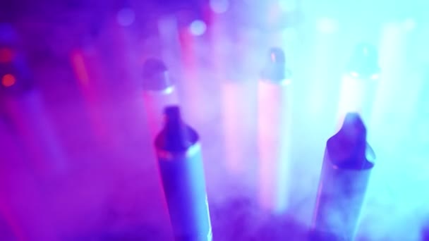 霓虹灯和烟雾中大量的电子香烟和录音带 恶习的概念 烟草产品的现代替代品 尼古丁成瘾 慢动作 — 图库视频影像