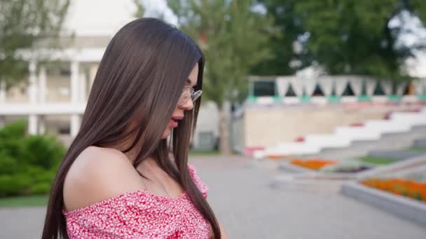 Szczęśliwa Brunetka Różowej Sukience Okularach Spaceruje Wzdłuż Ulicy City Uśmiecha — Wideo stockowe