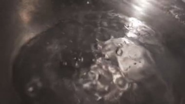 Water is boiling in a pot on the stove. Boiling water in slow motion.