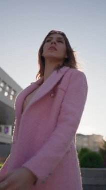 Pembe Ceketli ve Elbiseli Güzel İş Kadını Şehir Sokağında Poz Veriyor. Dikey Video, Yavaş Hareket.