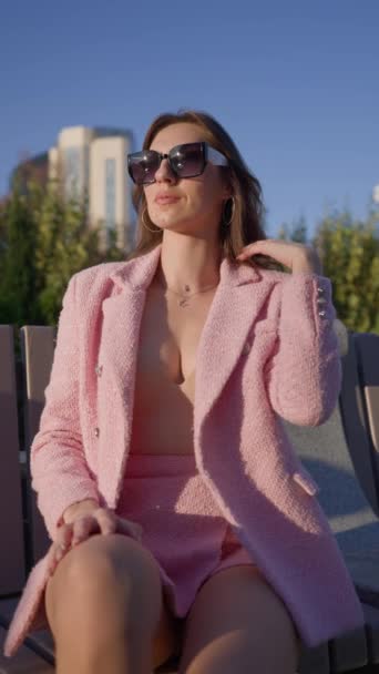 Piękna Kobieta Różowym Stroju Biznesowym Pozuje Siedząc Ławce Parku Miejskim — Wideo stockowe