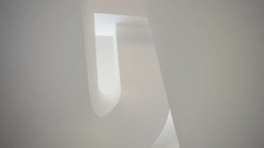 Minimalist bir iç mekanda kıvrımlı bir tarzda güzel, lüks, beyaz bir merdiven. Yavaş çekim, alt açı.