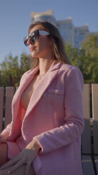 Beautiful Woman Pink Business Outfit Poses Ενώ Κάθεστε Ένα Παγκάκι — Αρχείο Βίντεο