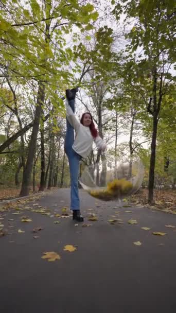 Happy Woman Jeans White Sweater Stands Split One Leg Raises — Αρχείο Βίντεο