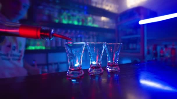 Guy Bartender Egy Alkoholos Koktélt Tölt Három Átlátszó Pohárba Egy — Stock videók