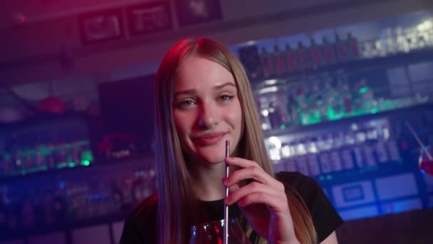 Portret Atrakcyjnej Uśmiechniętej Dziewczyny Pijącej Czerwony Koktajl Barze Neon Lighting — Wideo stockowe