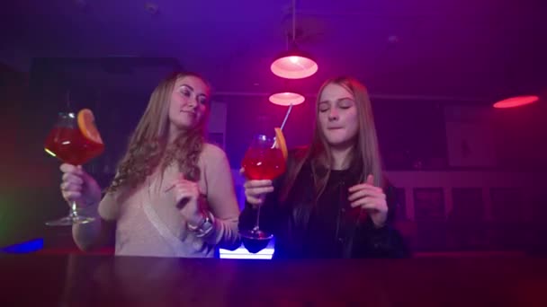 Две Подруги Танцуют Коктейлями Руках Возле Барной Стойки Ночном Клубе — стоковое видео