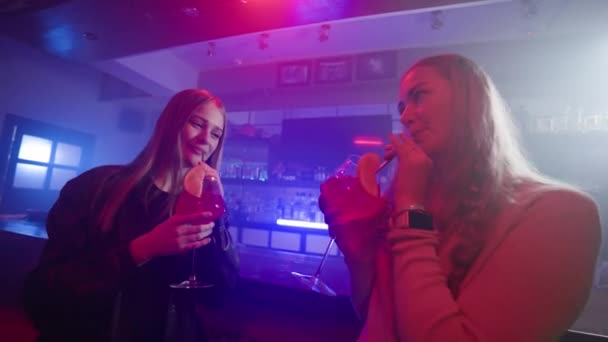 Две Подруги Танцуют Коктейлями Руках Возле Барной Стойки Ночном Клубе — стоковое видео