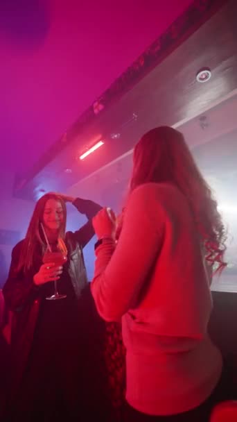 Вертикальное Видео Две Подруги Танцуют Коктейлями Руках Возле Барной Стойки — стоковое видео
