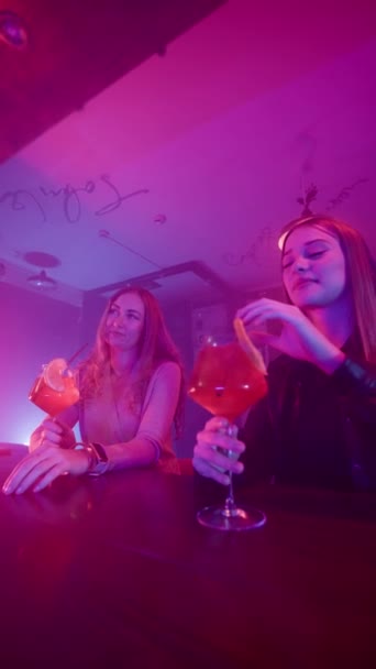Dos Mujeres Sonrientes Beben Cócteles Alcohólicos Rojos Mostrador Bar Club — Vídeos de Stock