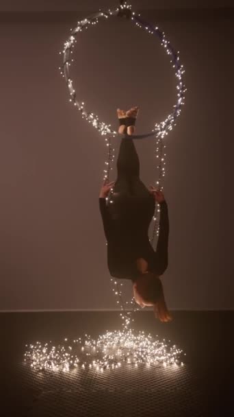 女飞行员从装饰着明亮圣诞花环的戒指上吊下来 健康生活方式和锻炼的概念 慢动作垂直录像 — 图库视频影像