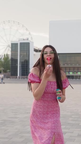 Πορτρέτο Happy Brunette Γυναίκα Φορώντας Γυαλιά Και Ροζ Φόρεμα Φυσώντας — Αρχείο Βίντεο