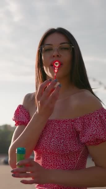 Πορτρέτο Happy Brunette Γυναίκα Φορώντας Γυαλιά Και Ροζ Φόρεμα Φυσώντας — Αρχείο Βίντεο