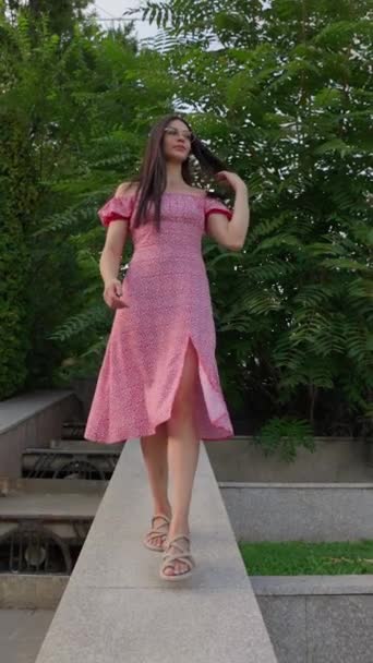 Młoda Uśmiechnięta Kobieta Okularach Różowej Sukience Spaceruje Parku Miejskim Ciągu — Wideo stockowe