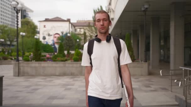 Serious Male Freelancer White Shirt Headphones Laptop Hands Walks City — Vídeos de Stock