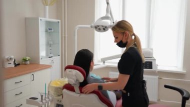 Sarışın Güzel Dişçi Diş Hekimliğinde Diş Tedavisine Hazırlanan Bir Hastayı Hazırlıyor. Kadın Mesleği ve Tıp Konsepti. Yavaş Hareket