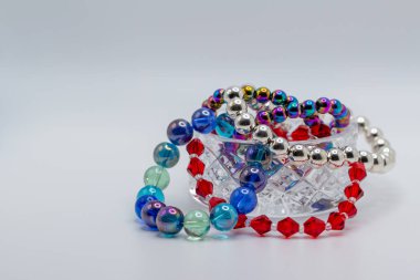 Bu resim, beyaz arkaplan ile renkli ve yanardöner boncuklar içeren güzel, küçük bir kurşun kristal kasenin makro bir görünümünü gösteriyor.