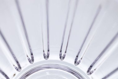 Defocused macro texture background of a shimmering modern lead crystal glass surface, with light reflecting line cuts