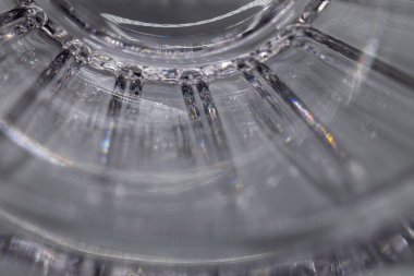 Defocused macro texture background of a shimmering modern lead crystal glass surface, with light reflecting line cuts