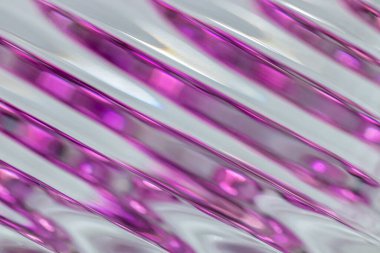 Çapraz çizgileri olan güzel bir modern kristal cam yüzeyin makro görünümlü soyut desen arkaplanı, bokeh ile mor rengi yansıtır.