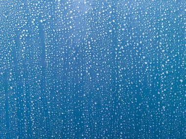 Duş duvarı yüzeyindeki su damlacıklarının mavi renk arkaplanını kapat