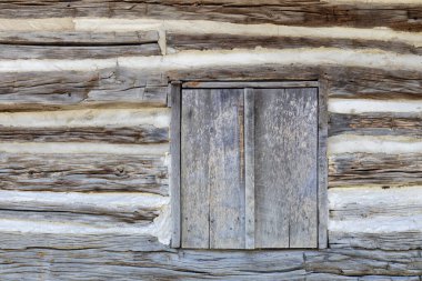 Eski bir ahşap 19. yüzyıldan kalma ahşap kulübe dış yüzeyinin soyut dokusunu kapatır ve penceresi tahta kaplıdır.