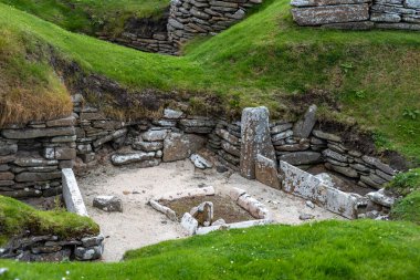 Landscape view of Skara Brae, a well preserved 5,000 year-old Neolithic village settlement on mainland Orkney Island in northern Scotland clipart