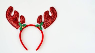 Beyaz arka planda kırmızı parlak noel boynuzları, dekoratif saç bandı, üst görünüm, düz yatak, fotokopi alanı. Noel veya yeni yıl partisi için dekor konsepti. Noel boynuzları.