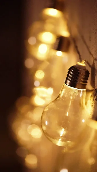 Glowing yellow light bulbs, realistic photo depiction of turning on a tungsten light bulb. Edison lamps in the interior. A garland of light bulbs.Copy space
