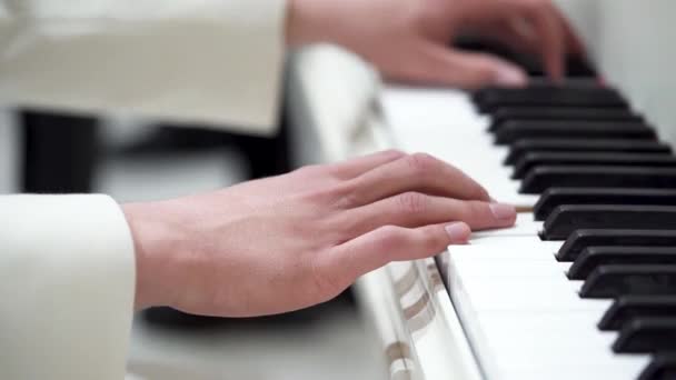 穿着白色夹克的年轻音乐家密切合作 在钢琴上演奏音乐 古典音乐 音乐会 钢琴课 键盘课 宏观视频 有选择的重点 — 图库视频影像