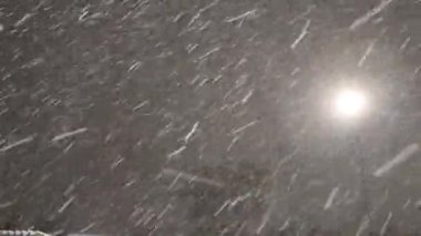  Sokak lambasının ışığına düşen karın dinamik videosu. Mevsimlik kar fırtınası, kar fırtınası. Gece vakti kar yağışı güçlü yağış yağışı, kışın kar taneleri.