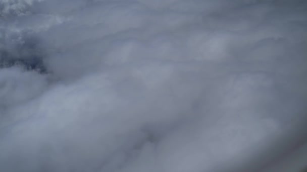 晴れた日の青空に白いふわふわの雲の上に飛行機の窓からの眺め 飛行機での休暇旅行 ビジネスフライト 美しい自然ビデオ4K スローモーション — ストック動画