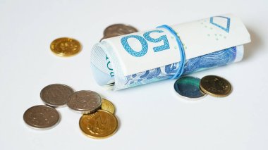 Beyaz arka planda zloti banknotları ve madeni paraların yakın plan fotoğrafı, Polonya parası. Başka bir ülkede döviz kuru kavramı. Avrupa Birliği 'nde enflasyon ve vergiler. Seçici odak