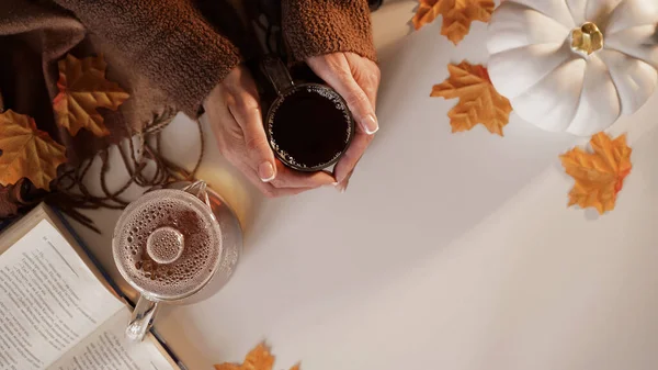 女性的手捧着一杯茶 玻璃壶 桔子枫叶 书肩并肩站在白底 顶视图 复制空间 初秋的概念 秋天的气氛 — 图库照片