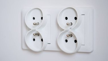 Beyaz bir duvara izole edilmiş çift avrupalı elektrik prizinin yakın çekimi. Mutfakta yeni bir dairede tadilat. Boşluğu kopyala