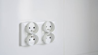 Beyaz bir duvara izole edilmiş çift avrupalı elektrik prizinin yakın çekimi. Mutfakta yeni bir dairede tadilat. Boşluğu kopyala