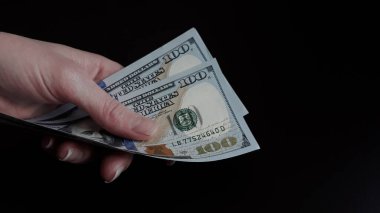 Kadın ellerinin 100 dolarlık banknotları tuttuğu yakın plan. Mal ve hizmetler için ödeme yapma, rüşvet alma, Amerikan parası, kopyalama alanı.
