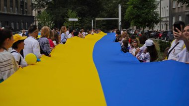 Ukrayna 'nın Bağımsızlık Günü, Ulusal Bayrak Günü, Anayasa Günü. İnsanlar 24 Ağustos' ta nakışlı gömleklerle büyük bir mavi-sarı bayrak açtılar. Polonya, Krakow 23.08.2023