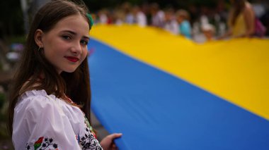 Ukrayna 'nın Bağımsızlık Günü, Ulusal Bayrak Günü, Anayasa Günü. İnsanlar 24 Ağustos' ta nakışlı gömleklerle büyük bir mavi-sarı bayrak açtılar. Polonya, Krakow 23.08.2023