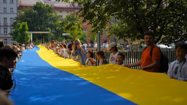 Ukrayna 'nın Bağımsızlık Günü, Ulusal Bayrak Günü, Anayasa Günü. İnsanlar 24 Ağustos' ta nakışlı gömleklerle büyük bir mavi-sarı bayrak açtılar. Polonya, Krakow 23.08.2023