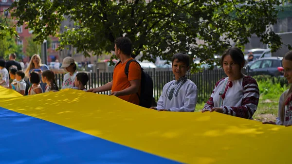 Ukrayna 'nın Bağımsızlık Günü, Ulusal Bayrak Günü, Anayasa Günü. İnsanlar 24 Ağustos' ta nakışlı gömleklerle büyük bir mavi-sarı bayrak açtılar. Polonya, Krakow 23.08.2023