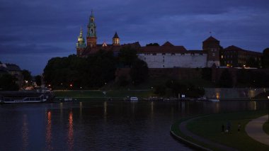 Gece Vistula nehrinin kıyısındaki eski güzel kraliyet Wawel Kalesi. Polanda popüler bir turizm merkezi olan Krakow 'un ana tarihi simgesi. Eski şehir, tatil ve seyahat yeri.