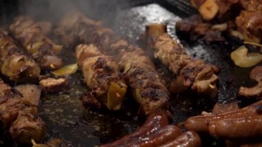 Akşam geleneksel sokak yemekleri festivalinde, kebap, et, sosis ve ızgarada biftek pişirmek. Şehrin ana meydanında şenlik, dumanda lezzetli et pişirmek..