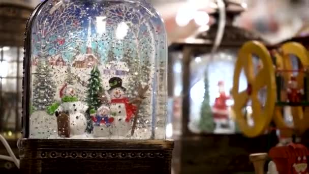 Nahaufnahme Einer Weihnachtsglasschneekugel Mit Einer Familie Von Schneemännern Und Fallendem — Stockvideo