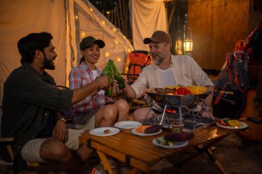 Grup turistleri kamp yapar, barbekü yapar, bira içer ve bira şişesini devirir.